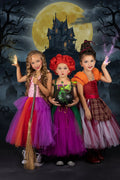 Girls wearing Winifred, Sarah, and Mary Sanderson-inspired Hocus Pocus tutu dresses with coordinating capes and decorative tulle brooms.