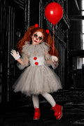 Pennywise's Twisted Carnival Tutu Dress & Accessory Set for girls featuring white tutu dress with red pom pom details, gloves, tights, red balloon and spooky clown costume accessories