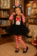 A young girl modeling a Dr. Seuss Cat in the Hat costume in a cozy, book-filled room.