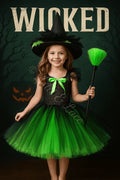 Elphaba's Emerald Enchantment Tutu Dress, Witch Hat & Wand Set featuring a black and emerald green layered tutu dress with matching witch hat and magical wand accessory for girls