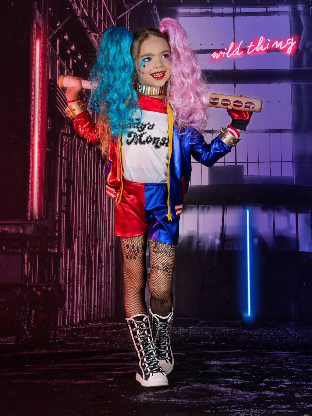 Girl's Harley Quinn costume set featuring red and blue jacket, matching shorts, two-tone wig, bat accessory, fishnet tights, and complete cosplay accessories.